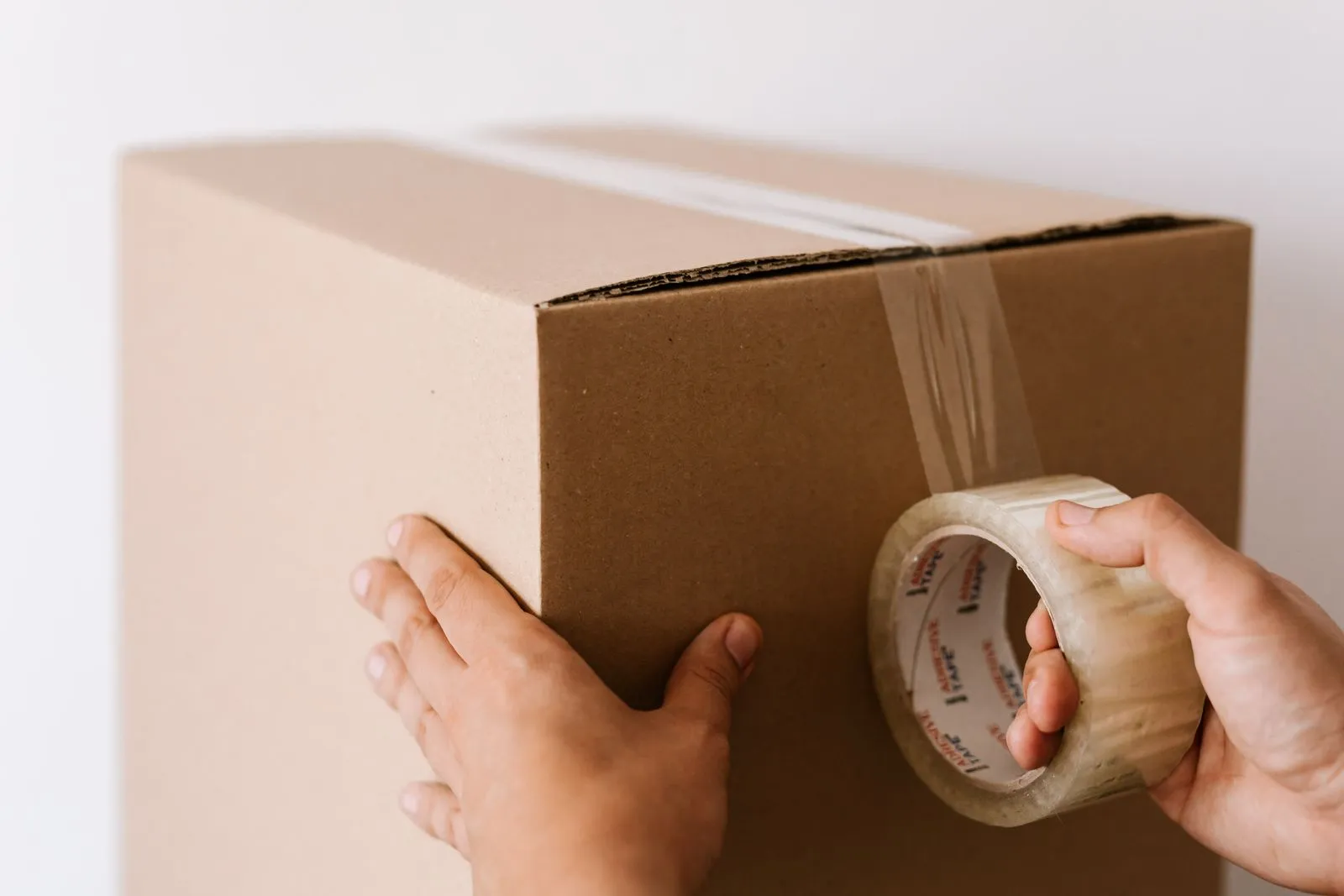 Sealing a sturdy double-walled cardboard moving box with packing tape
